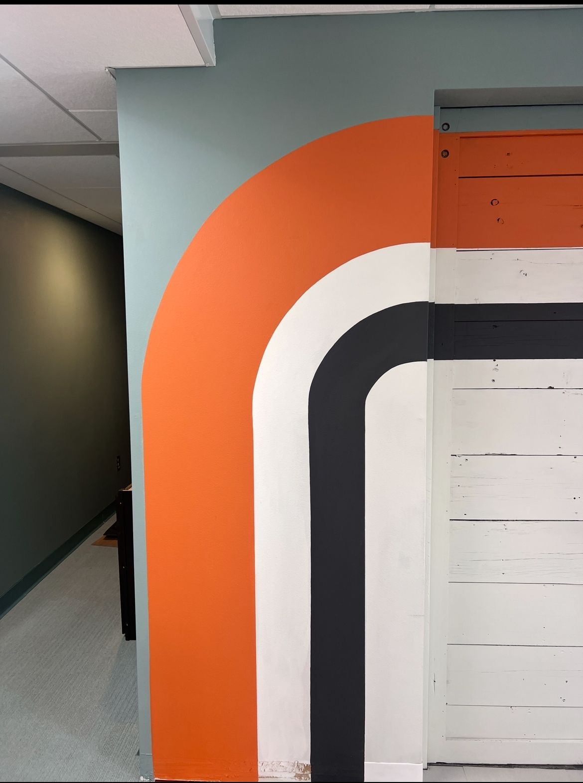 Orange, white and black stripe mural that lines up with the floor
