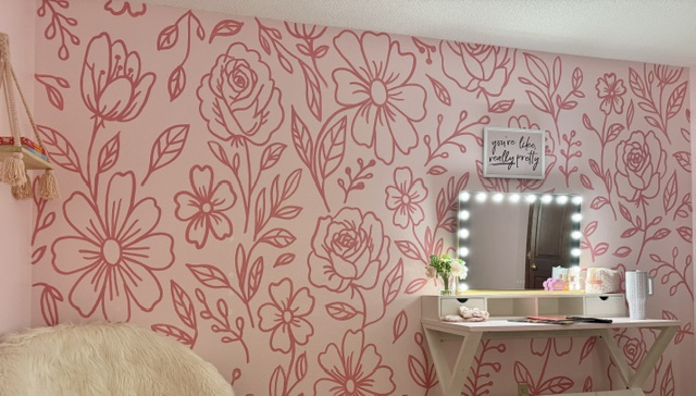 Mural of flowers on a pink wall in a bedroom